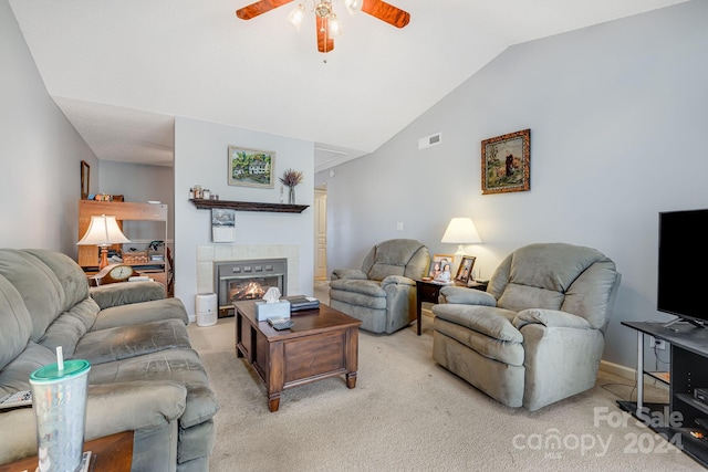 living room featuring a tile fireplace, light colored carpet, ceiling fan, and lofted ceiling