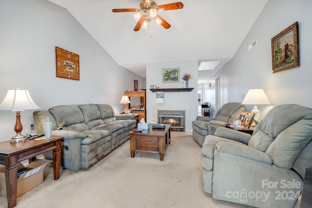 living room with light carpet, a tile fireplace, ceiling fan, and lofted ceiling