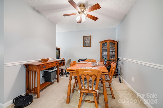 dining space with ceiling fan, a textured ceiling, and light carpet