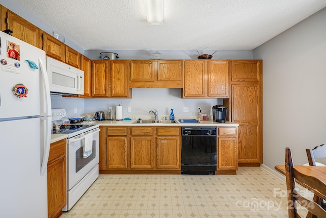 kitchen featuring a textured ceiling, white appliances, and sink