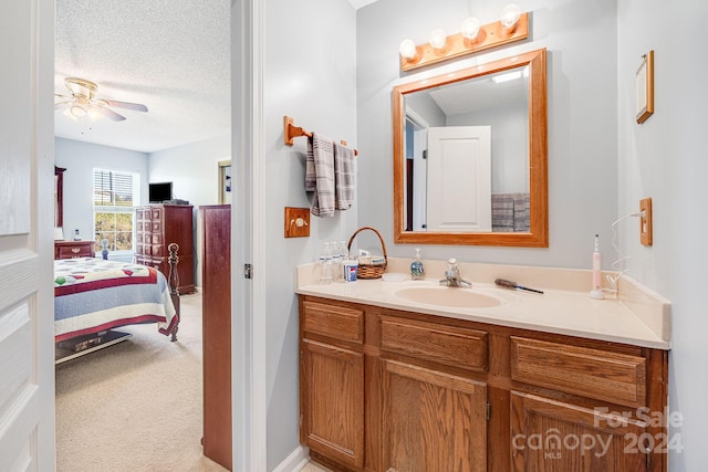 bathroom featuring vanity, a textured ceiling, and ceiling fan