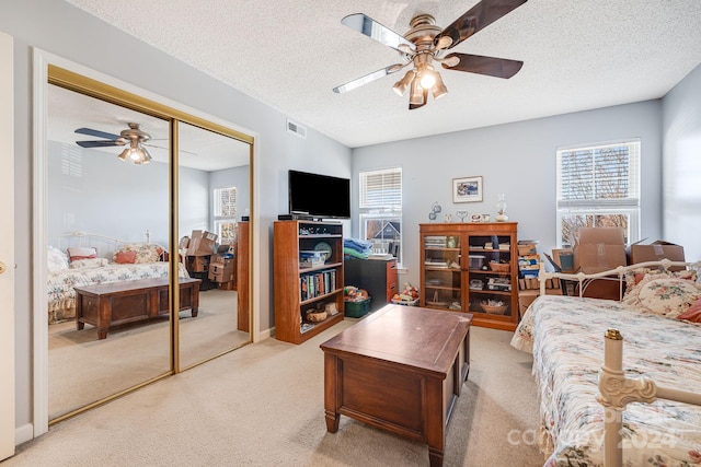 carpeted living room with ceiling fan and a textured ceiling