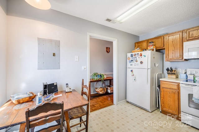 kitchen featuring a textured ceiling, white appliances, and electric panel