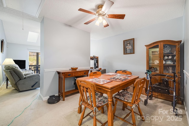 dining room featuring a textured ceiling, light colored carpet, and ceiling fan