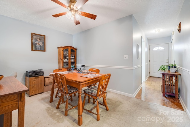 carpeted dining space featuring a textured ceiling and ceiling fan