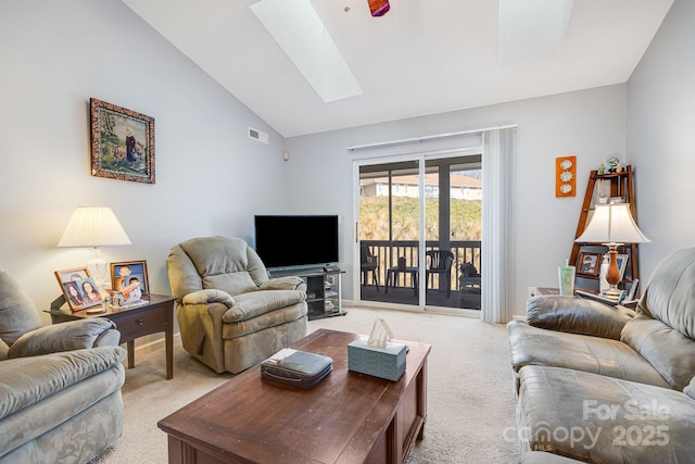 carpeted living room with lofted ceiling with skylight