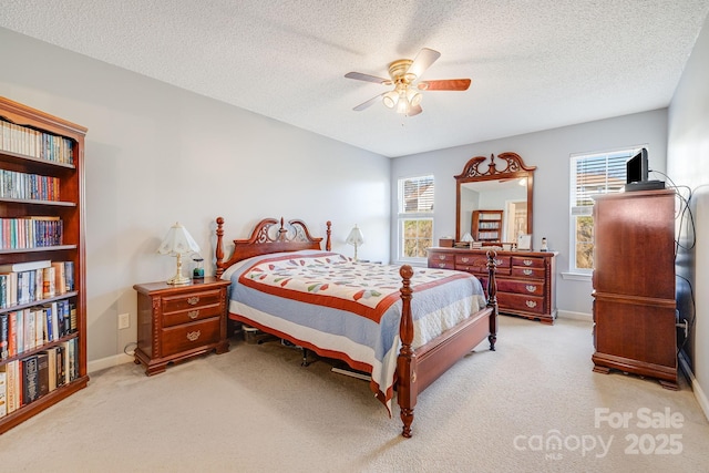 bedroom featuring a textured ceiling, ceiling fan, and light colored carpet