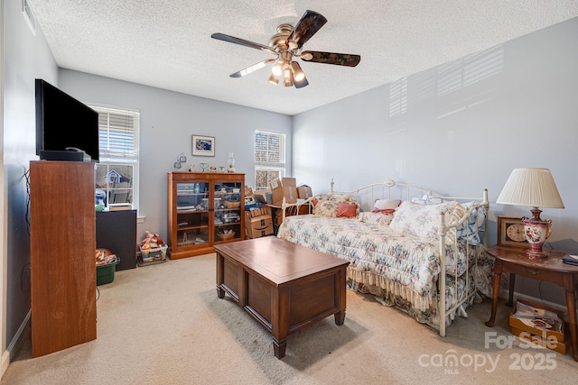 bedroom featuring ceiling fan, light carpet, and a textured ceiling