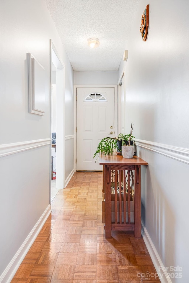 interior space with a textured ceiling and light parquet floors