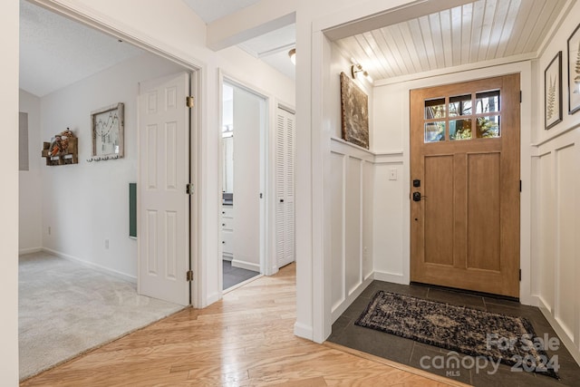 entrance foyer with light wood-type flooring and wood ceiling