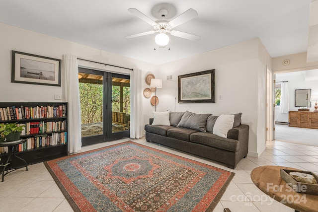 tiled living room with ceiling fan and a baseboard radiator