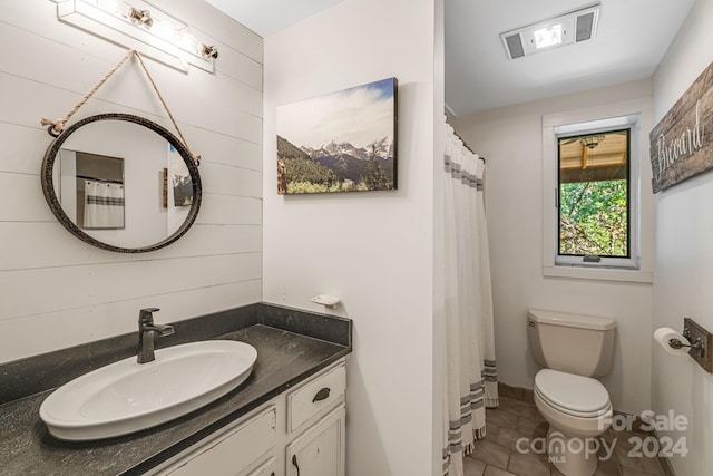 bathroom with tile patterned flooring, vanity, and toilet