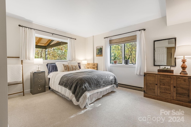 bedroom with light carpet, baseboard heating, and multiple windows