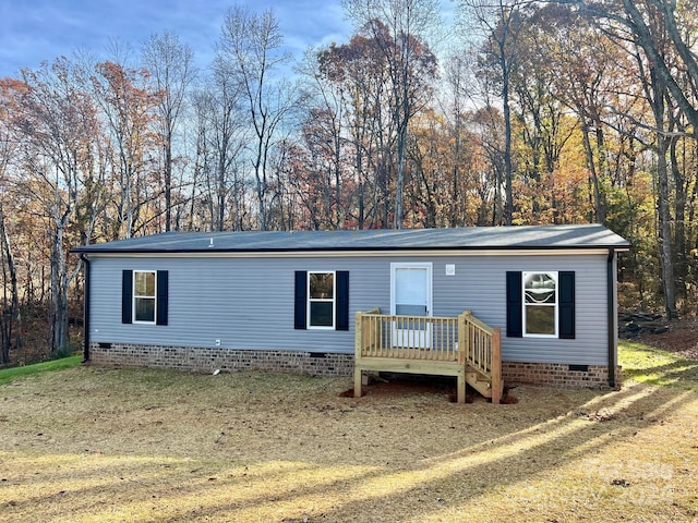 view of front of house with a deck and a front lawn