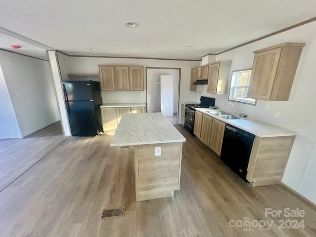 kitchen with light brown cabinetry, sink, black appliances, light hardwood / wood-style flooring, and a center island