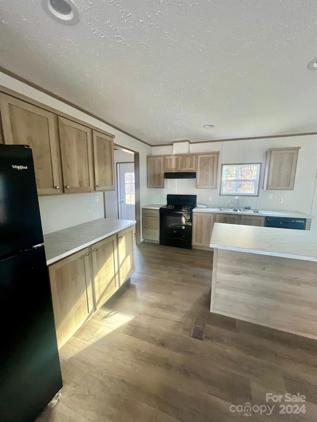 kitchen featuring wood-type flooring, a textured ceiling, and black appliances