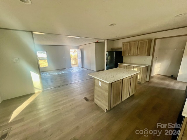 kitchen featuring black refrigerator, light hardwood / wood-style floors, and a kitchen island