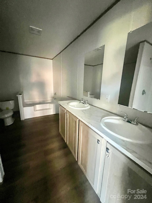 bathroom with hardwood / wood-style floors, vanity, and toilet