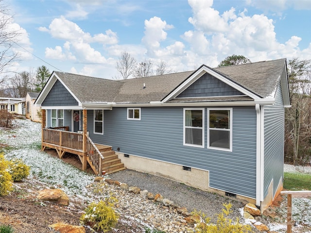 rear view of property with crawl space, a deck, and a shingled roof