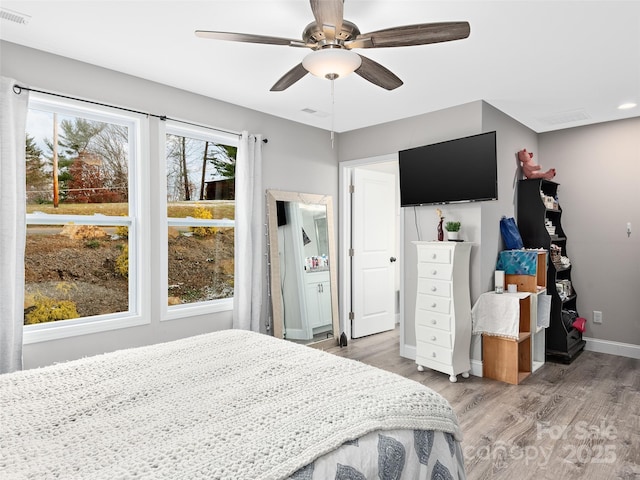 bedroom featuring light wood-type flooring, baseboards, visible vents, and ceiling fan