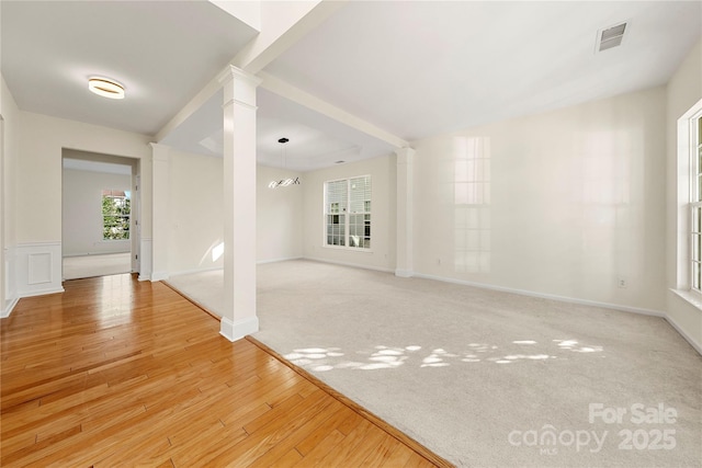 carpeted spare room featuring a chandelier