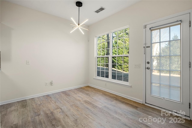 interior space with light hardwood / wood-style floors and a chandelier