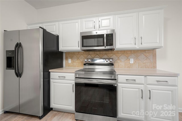 kitchen featuring appliances with stainless steel finishes, white cabinetry, and light hardwood / wood-style floors