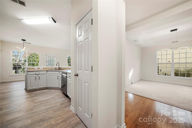 hall with sink, a chandelier, and light hardwood / wood-style flooring