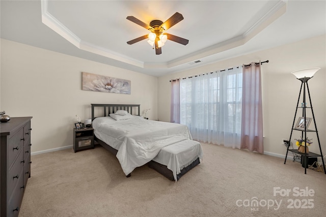 carpeted bedroom featuring ceiling fan, a tray ceiling, and crown molding