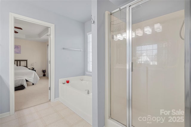 bathroom with ceiling fan, a raised ceiling, and shower with separate bathtub