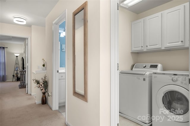 washroom featuring cabinets, washer and clothes dryer, and light carpet