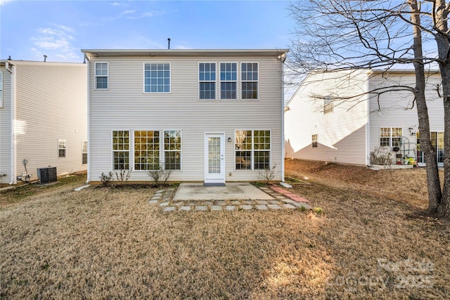 rear view of property featuring a lawn, a patio area, and central AC unit