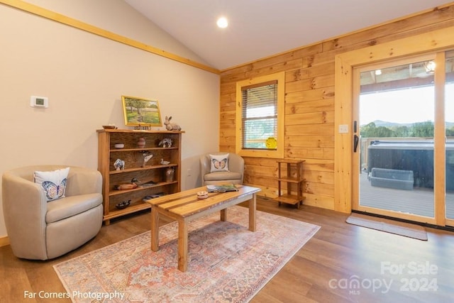 office area featuring hardwood / wood-style flooring, wood walls, and vaulted ceiling