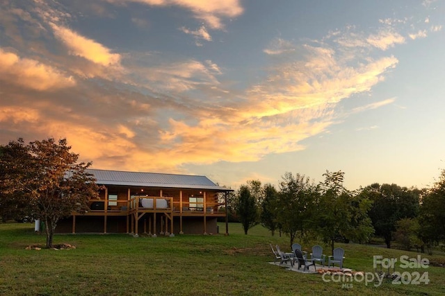 back house at dusk with a deck and a yard