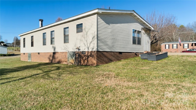 view of side of home with a yard