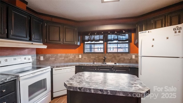 kitchen with decorative backsplash, white appliances, a kitchen island, and sink