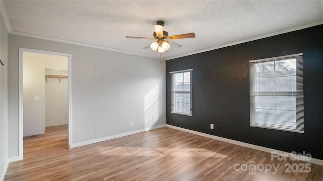 spare room with hardwood / wood-style floors, a textured ceiling, ceiling fan, and ornamental molding