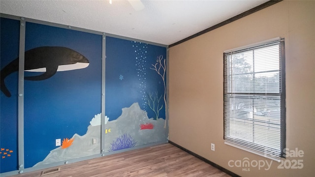 empty room featuring hardwood / wood-style flooring and ornamental molding