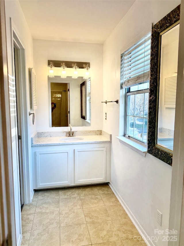 bathroom featuring a wealth of natural light, tile patterned flooring, and vanity