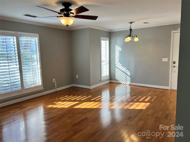 unfurnished room with crown molding, ceiling fan with notable chandelier, and dark hardwood / wood-style floors