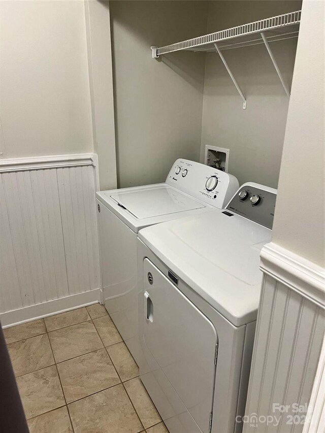 laundry room featuring washer and clothes dryer and light tile patterned flooring