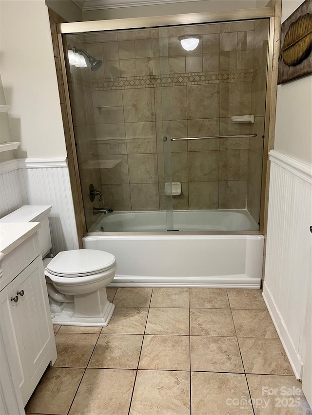 full bath with toilet, a wainscoted wall, tile patterned flooring, and vanity