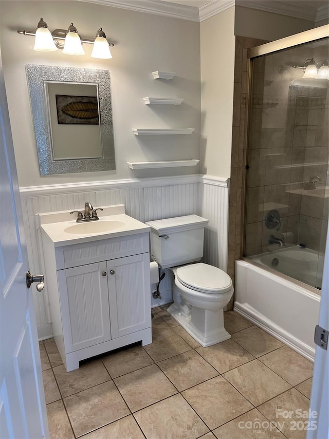 bathroom with bath / shower combo with glass door, ornamental molding, wainscoting, vanity, and tile patterned floors