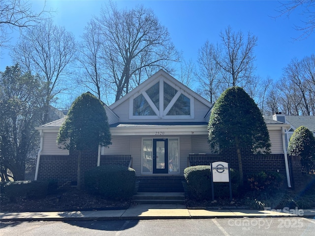 view of front of home featuring covered porch and brick siding