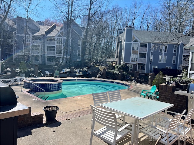 view of pool featuring a pool with connected hot tub and a patio