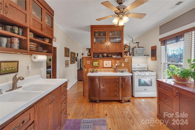 kitchen featuring white gas stove, light hardwood / wood-style floors, sink, and ceiling fan