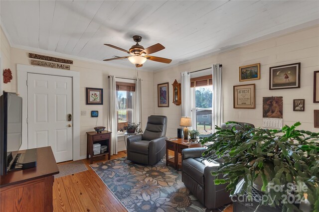 living room with ceiling fan, hardwood / wood-style floors, and crown molding