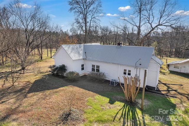 rear view of house with a lawn and central AC unit