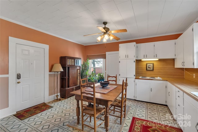 dining space with ceiling fan, light tile patterned floors, and crown molding