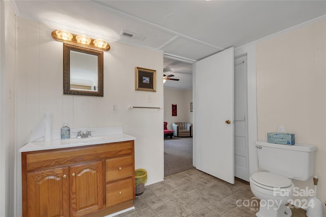 bathroom featuring ceiling fan, toilet, crown molding, and vanity